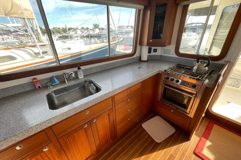 Spray Yacht Photos Pics Galley of 2015 Nordic Tug 39 with wooden cabinetry, stove, and sink, overlooking marina.