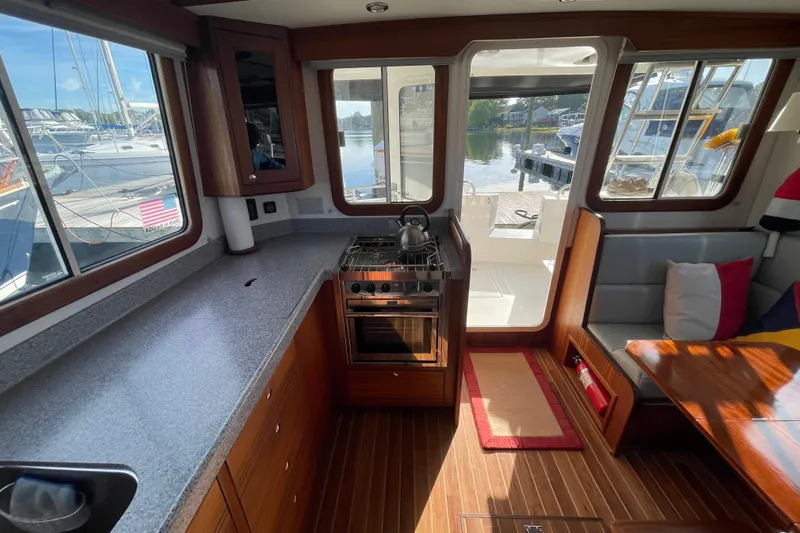 Spray Yacht Photos Pics Interior of 2015 Nordic Tug 39 with kitchen and seating area, dock view.