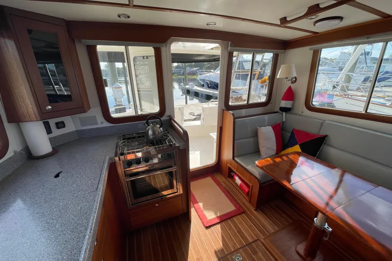 Spray Yacht Photos Pics Cozy interior of a 2015 Nordic Tug 39 with kitchen and dining area.