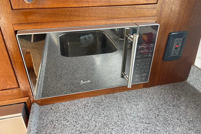 Spray Yacht Photos Pics Microwave in 2015 Nordic Tug 39 galley with wood cabinetry and granite countertop.