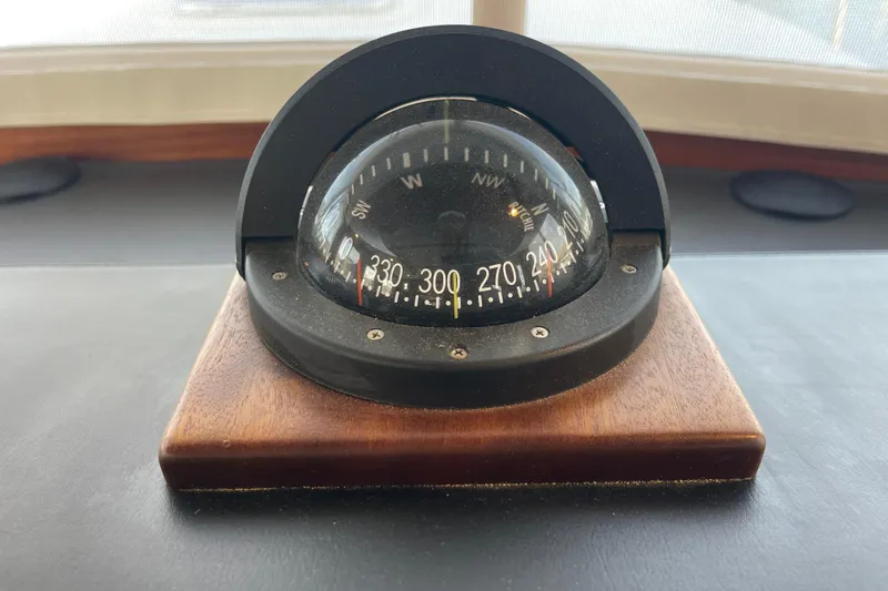Spray Yacht Photos Pics Compass on 2015 Nordic Tug 39, mounted on wooden base, displaying cardinal directions.