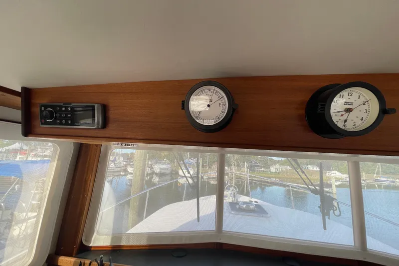 Spray Yacht Photos Pics Interior view of a 2015 Nordic Tug 39 with navigation instruments and a scenic marina backdrop.
