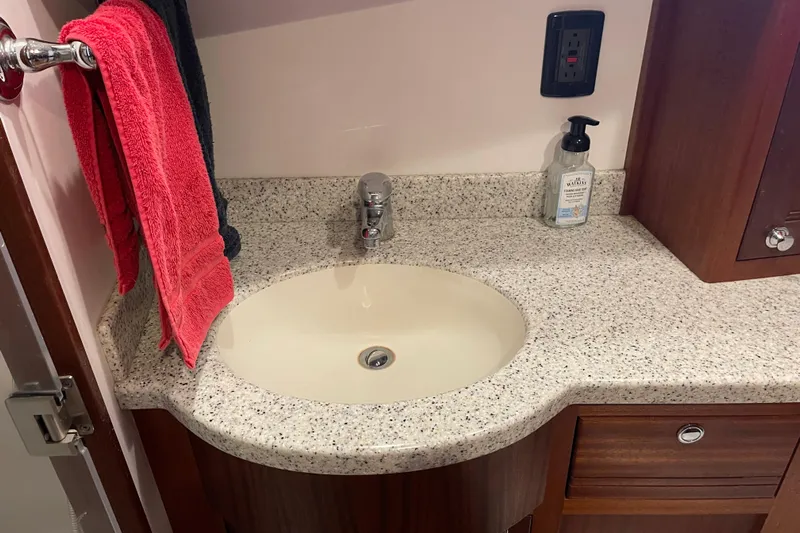 Spray Yacht Photos Pics Bathroom sink area in a 2015 Nordic Tug 39, featuring granite countertop and wooden cabinetry.