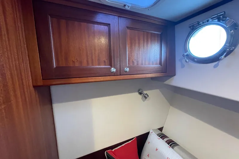 Spray Yacht Photos Pics Cozy cabin interior of 2015 Nordic Tug 39 with wooden cabinets and porthole window.