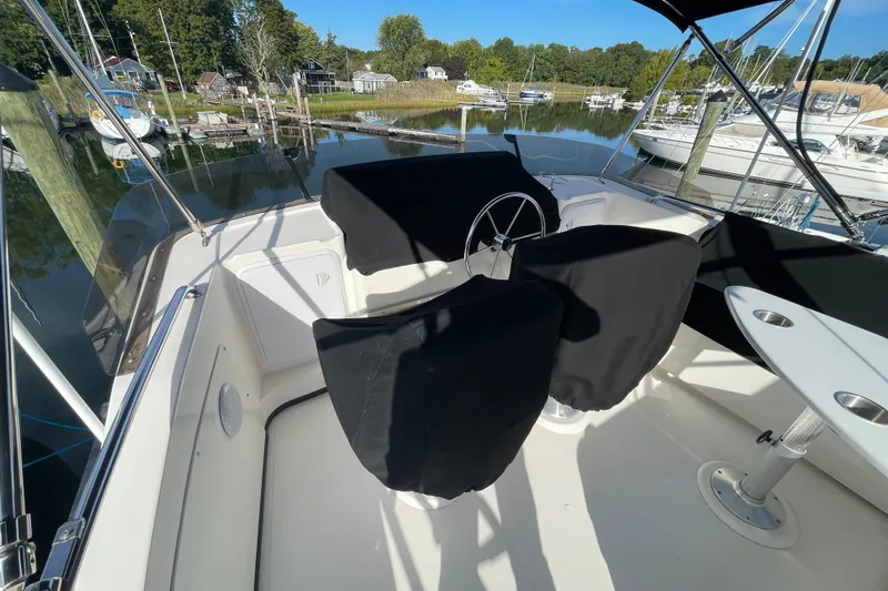 Spray Yacht Photos Pics 2015 Nordic Tug 39 boat cockpit with covered seats and steering wheel in marina.