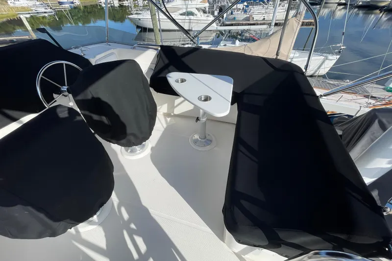 Spray Yacht Photos Pics Flybridge of 2015 Nordic Tug 39 with covered seating and steering wheel, docked at marina.