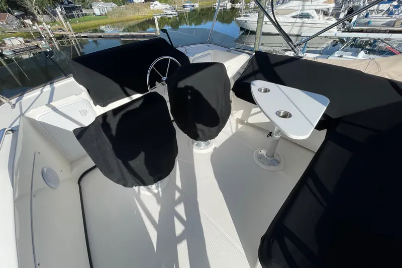 Spray Yacht Photos Pics Flybridge of 2015 Nordic Tug 39 with covered seating and table, docked at marina.