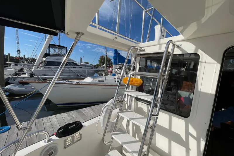 Spray Yacht Photos Pics 2015 Nordic Tug 39 at marina, featuring exterior ladder and docked sailboats.