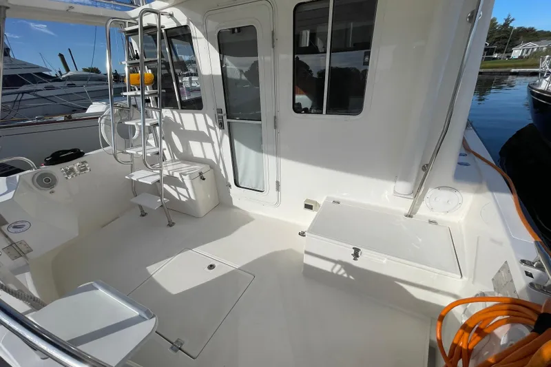 Spray Yacht Photos Pics 2015 Nordic Tug 39 boat deck with seating, ladder, and storage compartments.