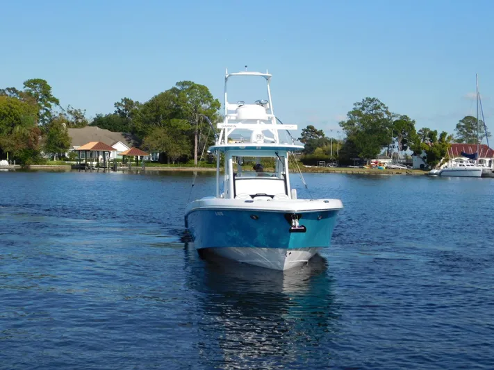  Yacht Photos Pics 2016 Everglades 355 Center Console boat on a serene lake with trees and houses.