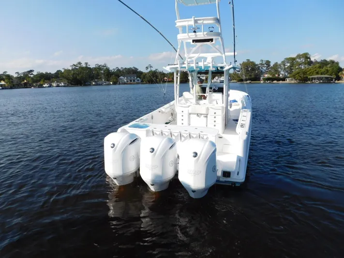  Yacht Photos Pics 2016 Everglades 355 Center Console boat with triple outboard engines on a calm lake.