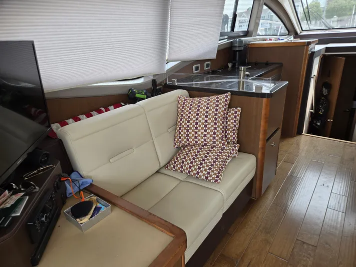 Precious Time Yacht Photos Pics Interior of 2017 Sea Ray Sundancer 400 yacht with sofa, cushions, and kitchenette.