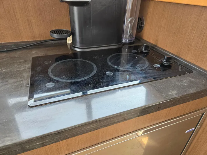 Precious Time Yacht Photos Pics Stovetop in 2017 Sea Ray Sundancer 400 yacht kitchen, featuring sleek black design.