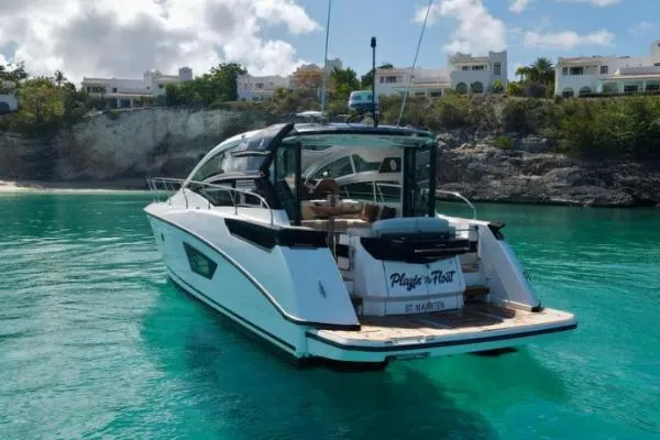 Sol Y Luna Yacht Photos Pics 2018 Beneteau 46 yacht anchored in turquoise waters near a rocky shoreline.