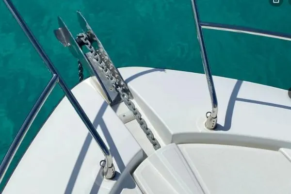 Sol Y Luna Yacht Photos Pics Bow of 2018 Beneteau 46 yacht with anchor chain over turquoise water.