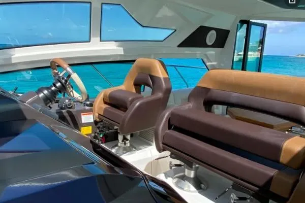 Sol Y Luna Yacht Photos Pics Interior view of 2018 Beneteau 46 yacht cockpit with brown leather seats and ocean backdrop.