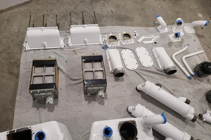  Yacht Photos Pics Various engine parts for a 1985 Post 43 Convertible boat displayed on a gray mat.