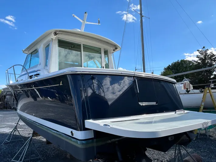  Yacht Photos Pics 2018 Back Cove 32 boat on stands, blue hull, clear sky background.