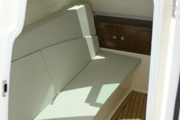  Yacht Photos Pics Interior cabin of 2021 Boston Whaler 320 Vantage with cushioned seating and wooden storage.