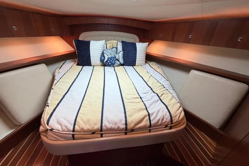  Yacht Photos Pics Luxurious cabin interior of 2007 Tiara Yachts 3900 Convertible with striped bedding.