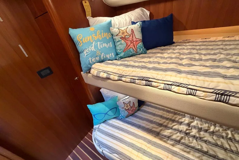  Yacht Photos Pics Cozy cabin interior of 2007 Tiara Yachts 3900 Convertible with striped bedding and decorative pillows.