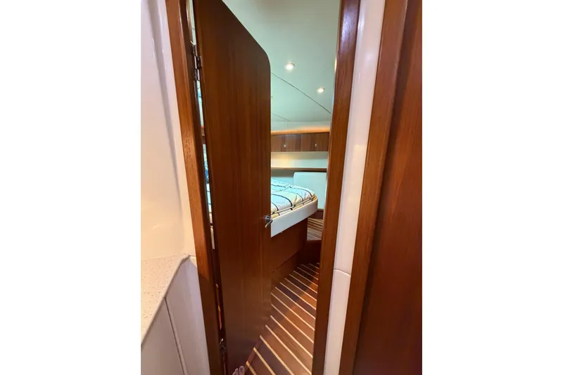  Yacht Photos Pics Interior view of 2007 Tiara Yachts 3900 Convertible cabin with wooden door and bed.