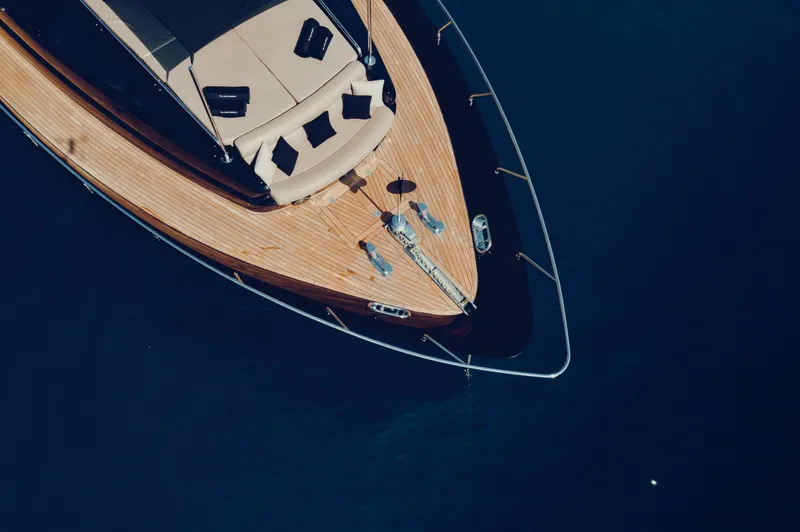Black Rock Yacht Photos Pics Aerial view of a 2008 Custom 77 yacht with wooden deck on blue water.