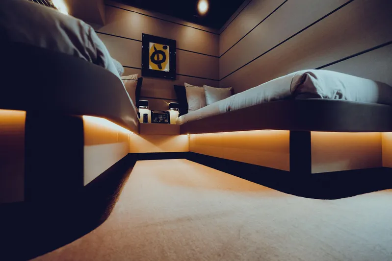 Black Rock Yacht Photos Pics Modern bedroom with ambient lighting, featuring two beds and abstract wall art.