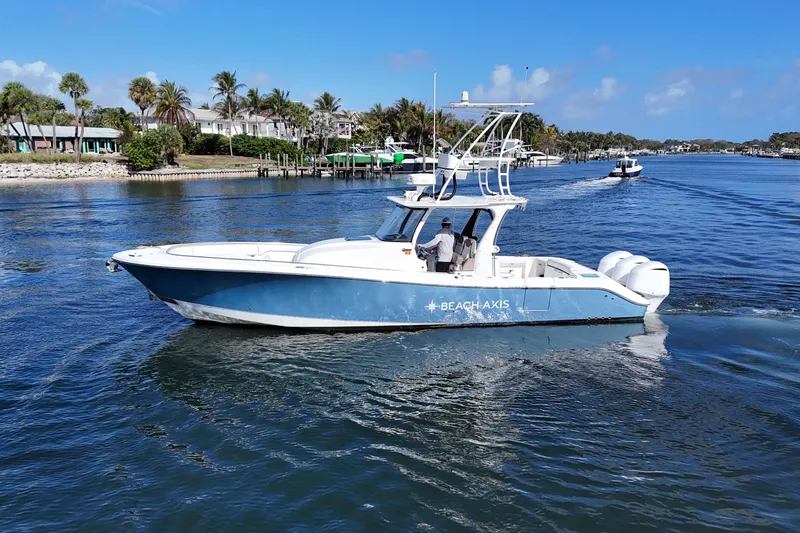  Yacht Photos Pics 2017 Edgewater 368CC boat cruising on a sunny day near palm-lined shore.