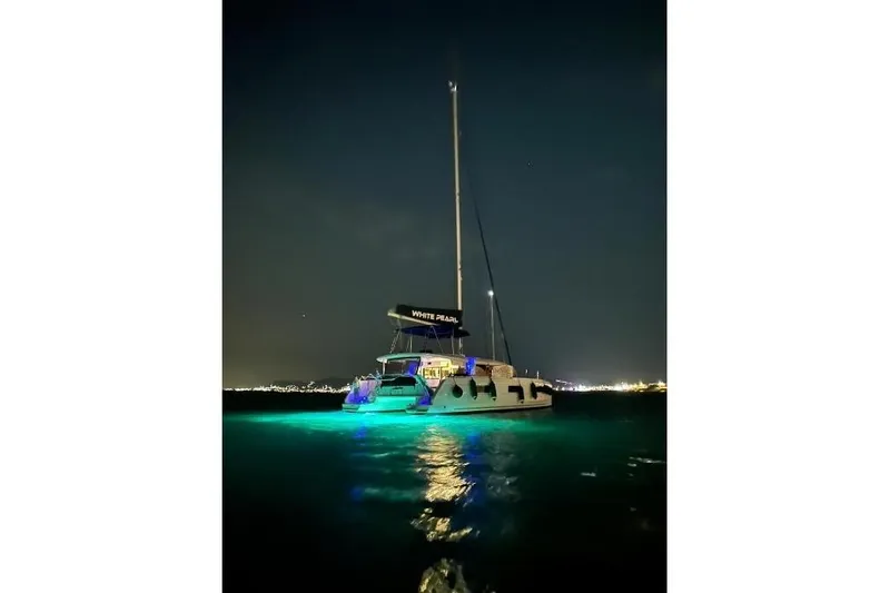  Yacht Photos Pics 2020 Lagoon 46 catamaran illuminated at night on calm waters.