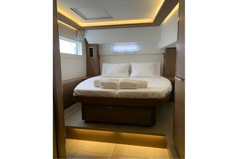  Yacht Photos Pics Luxurious cabin interior of 2020 Lagoon 46 yacht with modern lighting and cozy bedding.