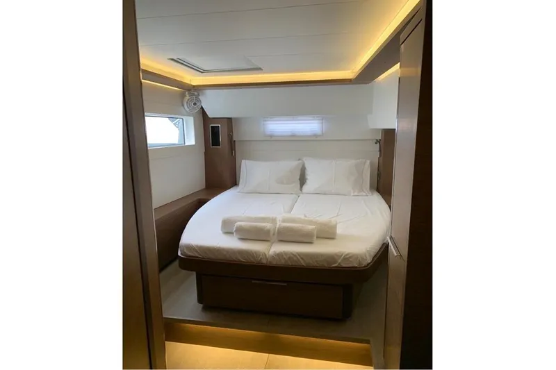  Yacht Photos Pics Luxurious cabin interior of 2020 Lagoon 46 yacht with cozy bed and ambient lighting.