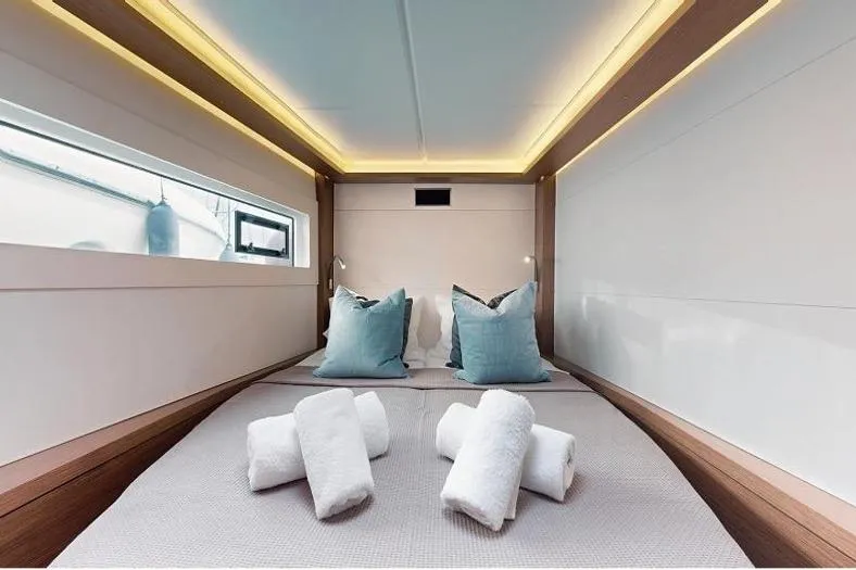  Yacht Photos Pics Luxurious cabin interior of 2020 Lagoon 46 yacht with plush bedding and soft lighting.