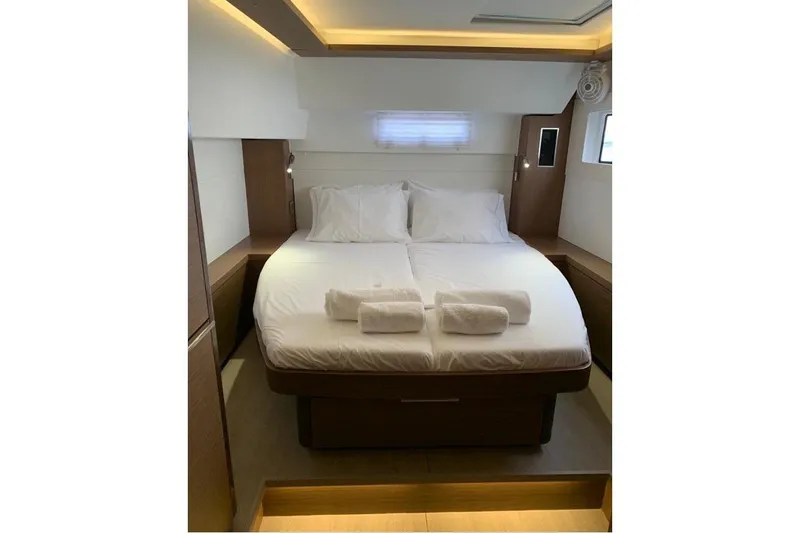  Yacht Photos Pics Luxurious bedroom interior of 2020 Lagoon 46 yacht with cozy bed and ambient lighting.