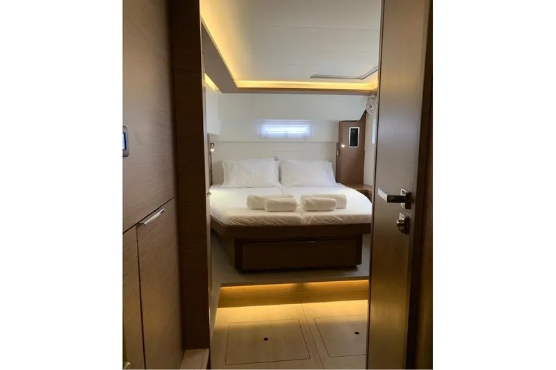  Yacht Photos Pics Luxurious cabin interior of 2020 Lagoon 46 yacht with cozy bed and ambient lighting.