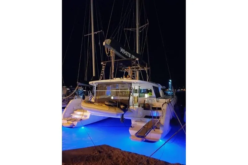  Yacht Photos Pics 2020 Lagoon 46 catamaran illuminated at night with blue underwater lights.