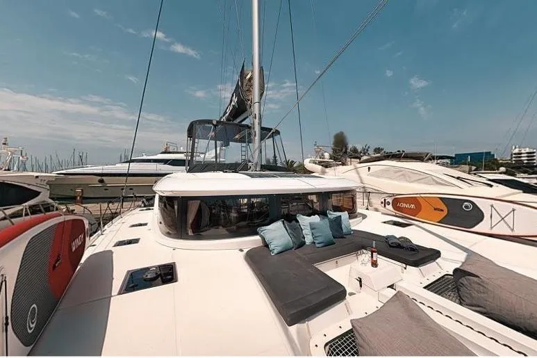  Yacht Photos Pics 2020 Lagoon 46 catamaran with sunbathing area and paddleboards docked at marina.