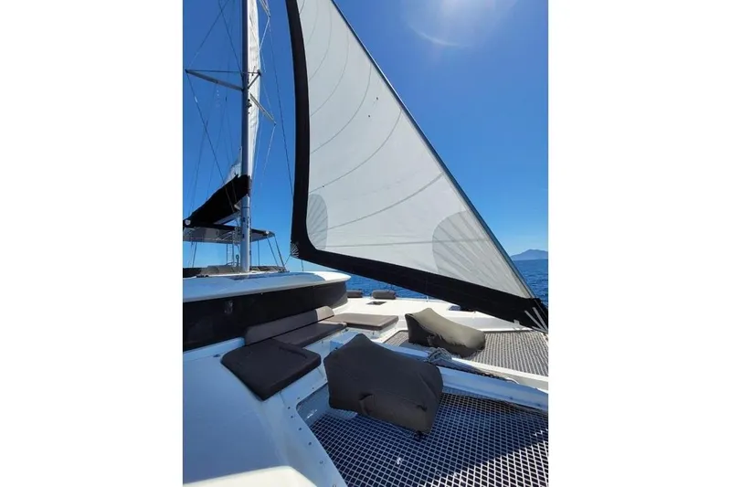  Yacht Photos Pics 2020 Lagoon 46 catamaran sailing on open sea under clear blue sky.