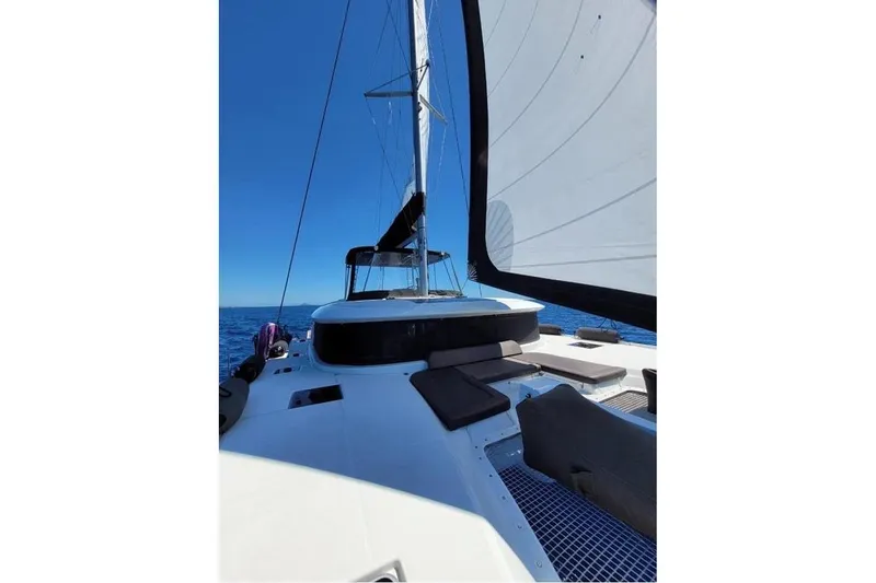  Yacht Photos Pics 2020 Lagoon 46 catamaran sailing on open sea under clear blue sky.