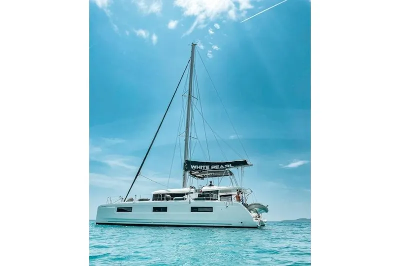 Yacht Photos Pics 2020 Lagoon 46 catamaran sailing on clear blue waters under a sunny sky.