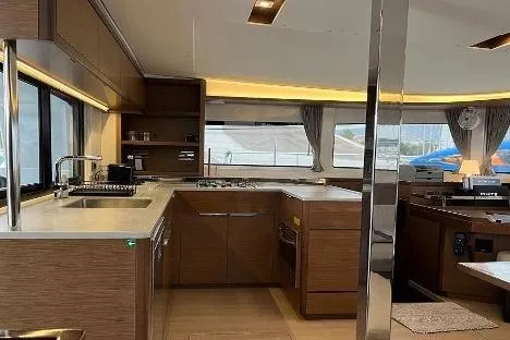  Yacht Photos Pics Modern kitchen interior of 2020 Lagoon 46 catamaran with wood finish and ample lighting.
