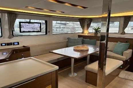  Yacht Photos Pics 2020 Lagoon 46 yacht interior with modern seating, dining table, and large windows.