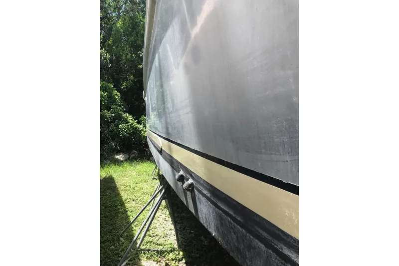 Tuff Baby Yacht Photos Pics Side view of a 1999 Custom Sport Fishing boat on land, surrounded by greenery.