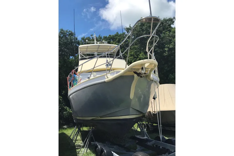 Tuff Baby Yacht Photos Pics Custom 1999 Sport Fishing boat on trailer, surrounded by trees under a blue sky.