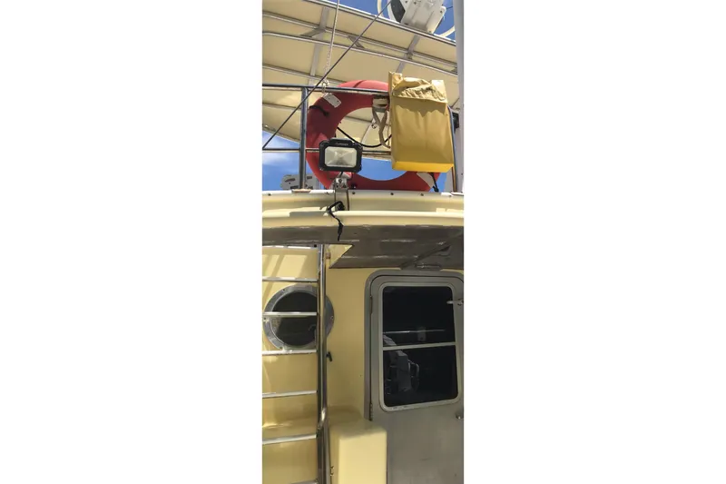 Tuff Baby Yacht Photos Pics 1999 Custom Sport Fishing boat with life preserver and ladder, under clear blue sky.