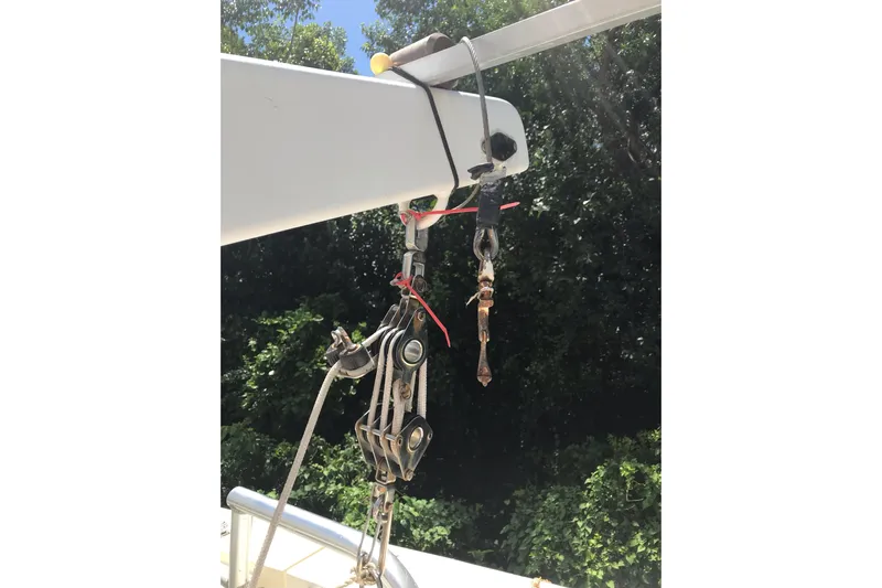 Tuff Baby Yacht Photos Pics Hanging rigging equipment on a 1999 Custom Sport Fishing boat against a forest backdrop.
