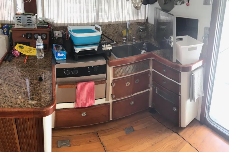 Tuff Baby Yacht Photos Pics Interior of a 1999 Custom Sport Fishing boat kitchen with wooden cabinets and granite countertops.