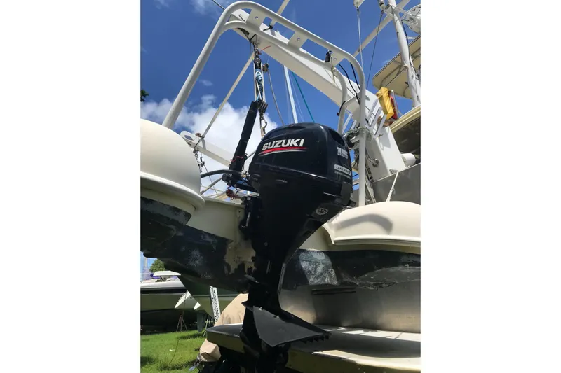 Tuff Baby Yacht Photos Pics Outboard motor on a 1999 Custom Sport Fishing boat under clear blue sky.