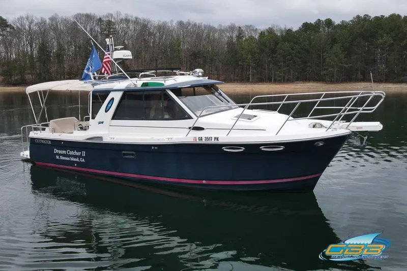  Yacht Photos Pics 2013 Cutwater C-28 boat "Dream Catcher II" on calm water near forested shoreline.