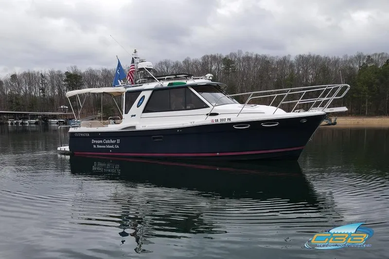  Yacht Photos Pics 2013 Cutwater C-28 boat, "Dream Catcher II," on calm water near wooded shoreline.